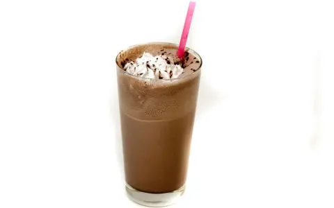 Un delizioso frappè al cioccolato con panna montata e una cannuccia rosa.