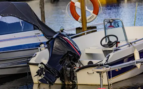 Moteur Mercury hors-bord sur un bateau blanc. Le moteur 2 temps ne démarre pas, il est temps de le réparer.