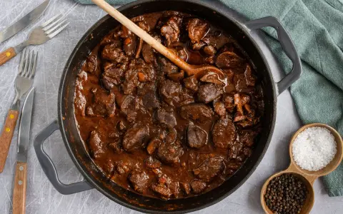 Herzhafter Rehgulasch in dunkler Sauce, bereit zum Schmoren. Die Frage "reh gulasch wie lange schmoren" wird hier visuell beantwortet: lange und langsam für zartes Fleisch.