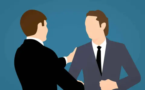 Deux hommes en costume se serrent la main, symbolisant un accord mutuel pour comment négocier une rupture conventionnelle.