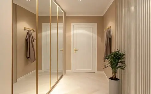 Elegancki przedpokój inspiracje ściany: lustrzana szafa, sztukateria i subtelne oświetlenie tworzą przytulną przestrzeń.