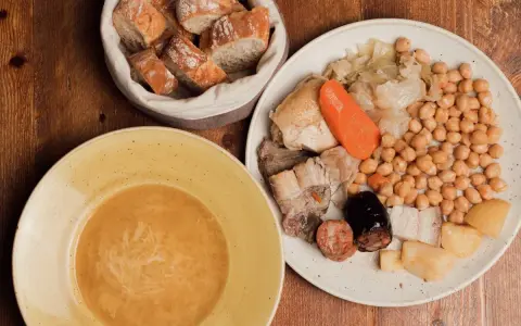 Un plato de comida típica de Madrid: cocido con garbanzos, carnes, verduras y pan.