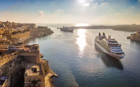 MSC Crociere: documenti di viaggio pronti per una crociera al tramonto tra fortezze storiche e navi maestose.