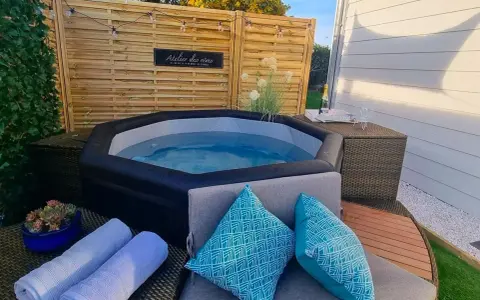 Ambiance relaxante autour d'un spa gonflable : coussins bleus, serviettes douces et guirlande lumineuse pour une deco parfaite.