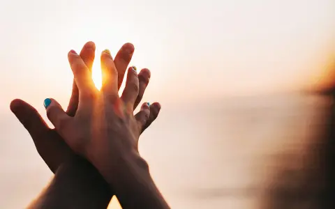 Two hands clasped at sunset, a symbol of purity and what is chastity: a deep, respectful connection.