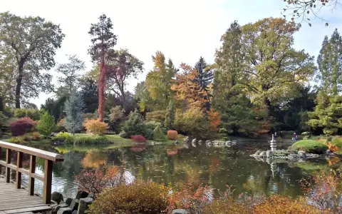 Jesienna odsłona jednego z najpiękniejszych ogrodów botanicznych w Polsce. Drewniany mostek, staw z odbiciami drzew i kamienna latarnia tworzą malowniczy krajobraz.