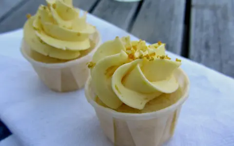 Två läckra citron cupcakes med gul frosting och strössel. Perfekt för en fika.