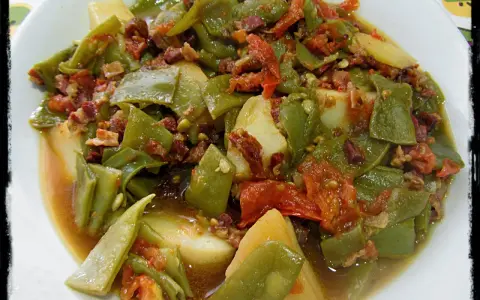 Judías verdes tiernas con patatas y trocitos de jamón, cocinadas en olla express. Un plato casero y delicioso.
