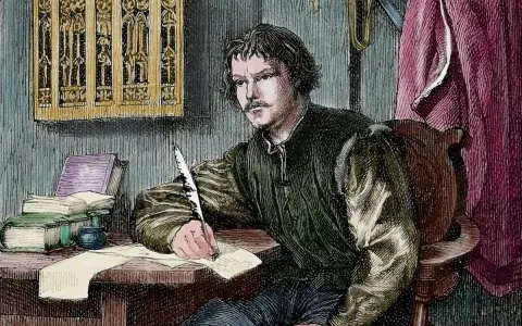 Martin Luther schreibt mit einer Feder. Wann wurde Martin Luther geboren? Die Frage beschäftigt Historiker seit Jahrhunderten.