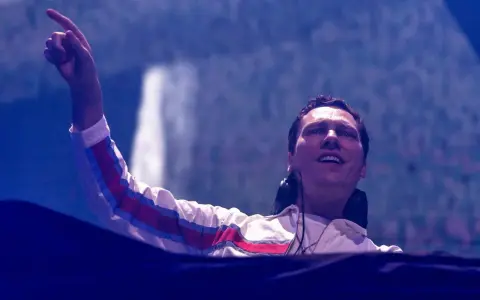 DJ Tiësto w Polsce, z palcem uniesionym w górę, wita publiczność.