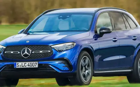 Blauer Mercedes-Benz GLC EQ Testfahrt auf einer grünen Wiese.