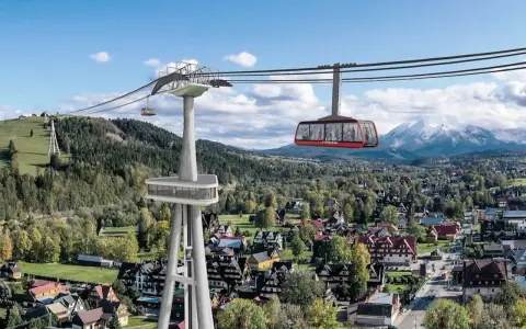 Nowe atrakcje Białki Tatrzańskiej i okolice: kolejka linowa z widokiem na Tatry, nowoczesna wieża widokowa i malownicze domy.