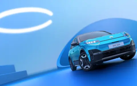 El Nissan Micra azul, con sus modernas luces y diseño, se presenta sobre un fondo abstracto. Conoce las medidas del Nissan Micra.