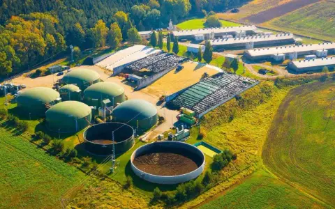 Planta de biogás con biodigestores y granjas. Las desventajas de la biomasa incluyen el uso de grandes extensiones de tierra y la necesidad de infraestructura.