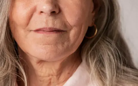 Gros plan sur le visage d'une femme âgée, montrant les rides autour de la bouche et du cou. Des conseils sur comment faire disparaître les rides profondes pourraient être utiles.
