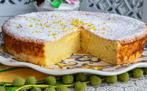 Un moelleux au citron, saupoudré de sucre glace et de zestes, attend d'être dégusté. Sa texture aérienne promet un délice.