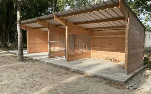 Nouveau box chevaux fait maison en bois, avec toit métallique et barrières en métal. Prêt à accueillir vos compagnons.