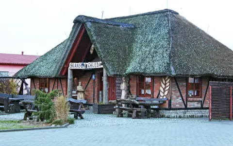 Skansen chleba z charakterystycznym, strzechą krytym dachem. Drewniane ławy i stoły zapraszają do odpoczynku.