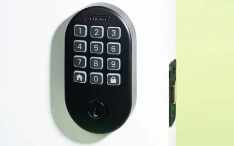 Black Schlage keypad lock on a white door, showing numbers and icons. Learn how to change door lock code for enhanced security.