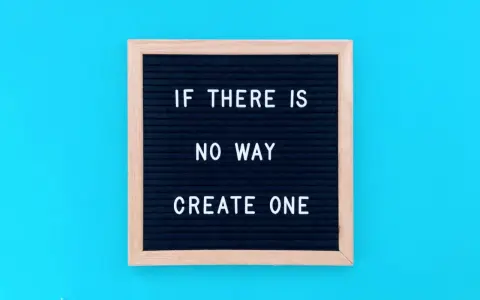Czarna tablica z białym napisem "IF THERE IS NO WAY CREATE ONE" na niebieskim tle.