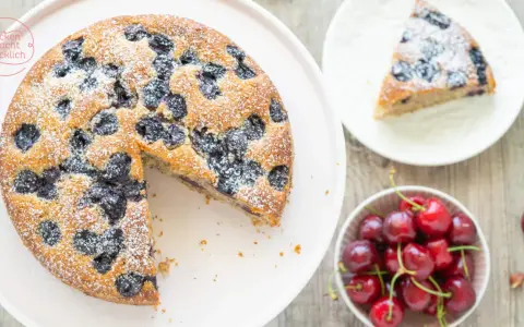 Saftiger Kirschkuchen, bestäubt mit Puderzucker. Ein köstliches kirschkuchen rezept für den Sommer.