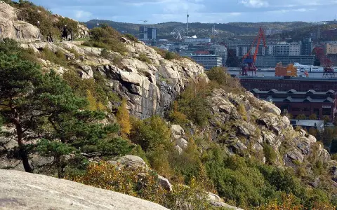 Steniga sluttningar med träd och buskar i Keillers park, med Göteborgs stad och hamnen i bakgrunden.