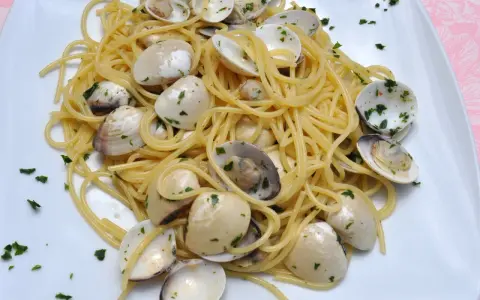 Pyszne Spaghetti con le Vongole przepis. Aromatyczny makaron z małżami i natką pietruszki, gotowy do podania.