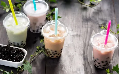 Różne rodzaje herbaty do bubble tea: zielona, mleczna, brązowa i różowa, z tapioką.