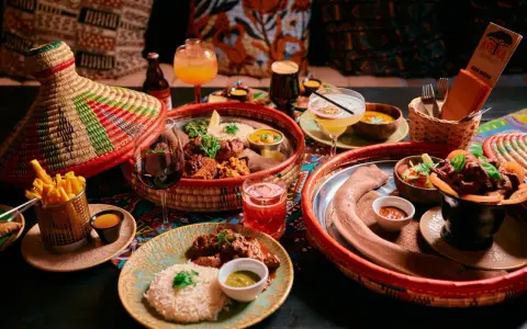En härlig måltid på en afrikansk restaurang med flera rätter, drycker och en färgglad duk.