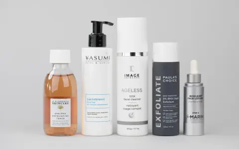 Zestaw kosmetyków do pielęgnacji, w tym tonik z kwasem AHA/PHA, żel z kwasem laktobionowym, cleanser, eksfoliant z kwasem BHA i lotion.