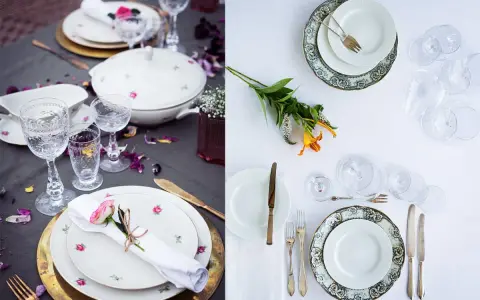 Vackert dukat bord med vita rosa tallrikar, glas och blommor. En romantisk middagsbjudning väntar.