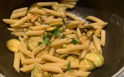 Penne con zucchine saltate e basilico fresco, un classico piatto di pasta e zucchine alla siciliana, pronto per essere gustato.