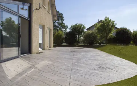 Terraza de hormigón impreso con diseño de brújula, mostrando cómo se hace el hormigón impreso para un acabado elegante y duradero.