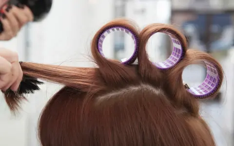 Profesjonalne styling włosów: lokówka i szczotka tworzą objętość.