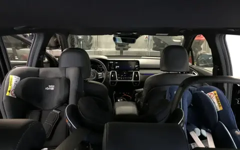 Wnętrze samochodu z dwoma fotelikami dziecięcymi. Z tyłu widać 3 isofix, gotowe na podróż z najmłodszymi.