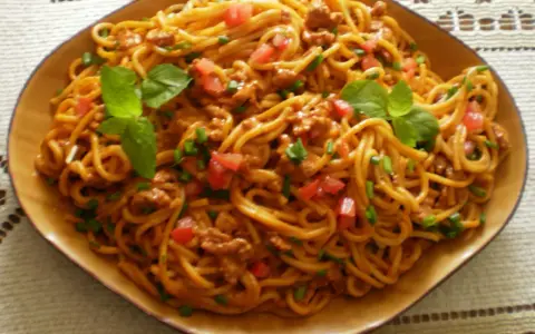 Spaghetti bolognese – prosty przepis. Aromatyczny sos mięsny z pomidorami i bazylią na złocistym makaronie.