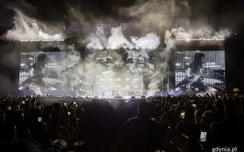 Koncert Linkin Park na Opener Festival. Tłum ludzi z telefonami, dym i światła na scenie.