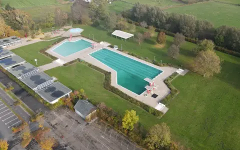 Luftaufnahme des Freibad Gehlenbeck mit Schwimmbecken, Sprungturm und Spielplatz.