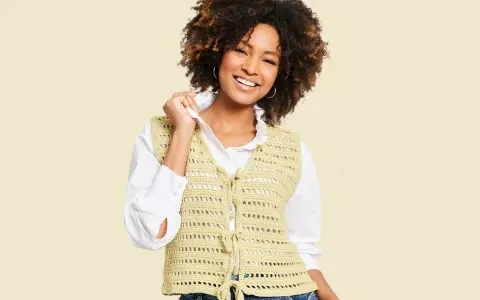Mujer sonriente con chaleco de crochet con patrón calado, atado al frente.