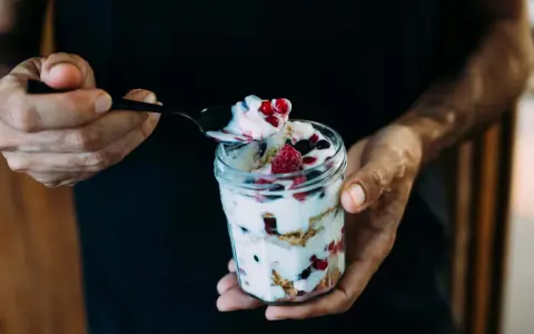 Ein Glas Magerquark mit Beeren, perfekt für den Muskelaufbau. Eine Löffelspitze voller Genuss.