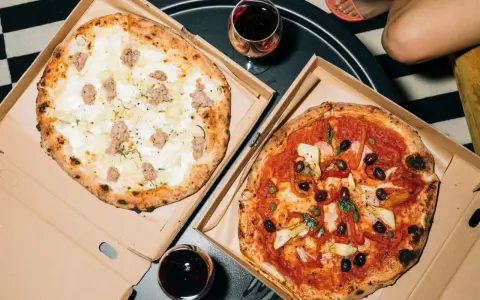 Dwie pyszne pizze: jedna biała z kiełbasą i ziemniakami, druga czerwona z oliwkami i karczochami. Takie są pizze na wieczór!