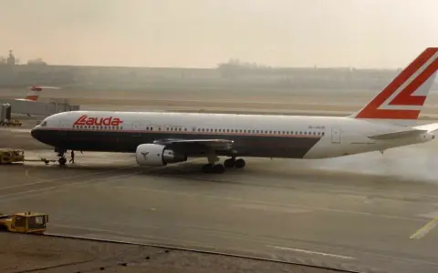 Samolot Lauda Air z charakterystycznym ogonem, kołujący po płycie lotniska.