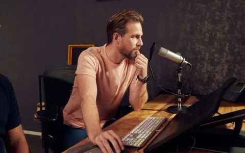 Un ingé son concentré devant son micro, prêt à enregistrer.