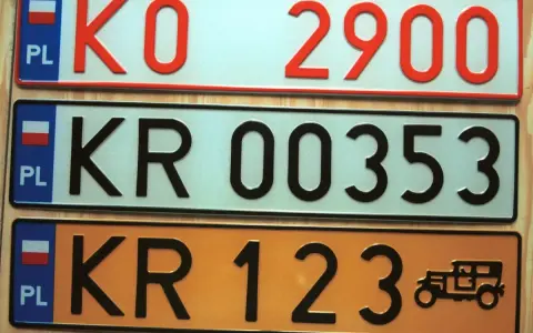 Kolekcja tablic rejestracyjnych świata: polskie tablice KO 2900, KR 00353 i KR 123 z zabytkowym autem.