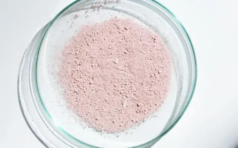 Polvere rosa in una capsula di Petri, un ingrediente che, come la niacinamide, è fotosensibilizzante.