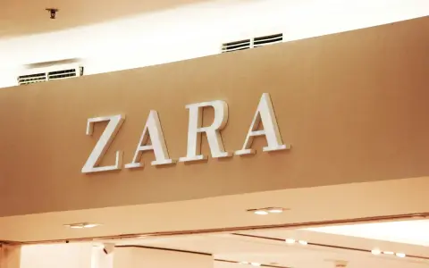 ZARA, znana marka odzieżowa, prezentuje swoje logo na jasnobrązowej ścianie.