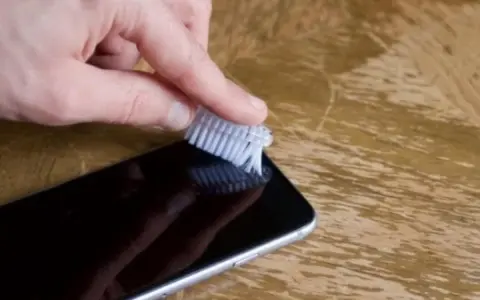 Delikatnie szczotkuj głośnik iPhone'a, aby usunąć kurz i brud. Prosty sposób, jak wyczyścić głośnik iPhone.
