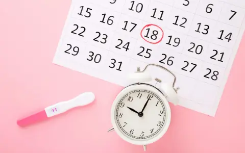 Test ciążowy i kalendarz z zaznaczonym dniem 18. Zegar obok sugeruje, że czas na badania prenatalne kiedyś nadejdzie.