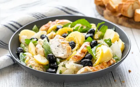 Insalata di pollo sfiziosa con patate, olive nere e limone, un piatto fresco e saporito.