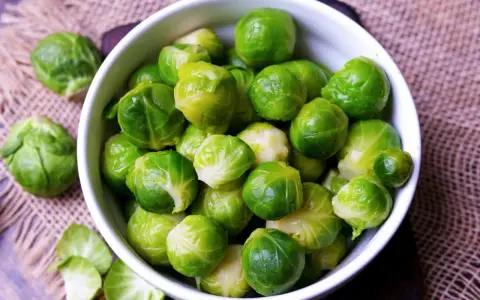 Frischer Rosenkohl in einer Schüssel. Die Frage "wie lange muss rosenkohl kochen" beschäftigt viele Hobbyköche.